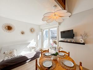 ein Esszimmer mit Tisch und Couch in der Unterkunft Le Roazhon Park - Balcon & Garage Privé - Duplex in Rennes