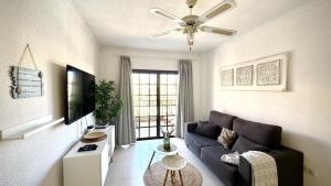 ein Wohnzimmer mit Sofa und Fernseher in der Unterkunft Verano Eterno Balcon del Mar by Deihu Experiences in Arona