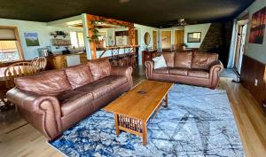 a living room with two leather couches and a coffee table at Lakeviewlanding in Big Arm