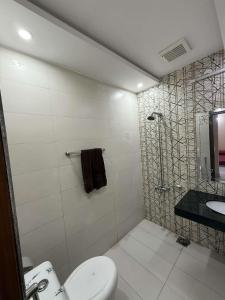 a bathroom with a shower and a toilet and a sink at The Cozy Nest in Lahore
