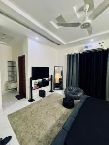 a living room with a couch and a tv at The Cozy Nest in Lahore +9 photos