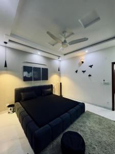 a bedroom with a large bed and a couch at The Cozy Nest in Lahore