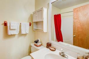 a bathroom with a white sink and a red shower curtain at Banner Bunks at River Run in Banner Elk +67 photos