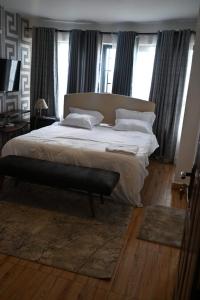 a bedroom with a large white bed with windows at Milele Homes- Ruaka View Aprt in Nairobi