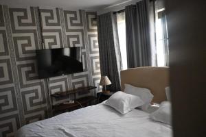 a bedroom with a bed and a tv on a wall at Milele Homes- Ruaka View Aprt in Nairobi