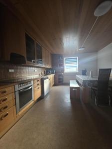a kitchen with wooden cabinets and a table in it at Wohnung Maric bis zu 10 Personen in Neunburg vorm Wald +5 photos