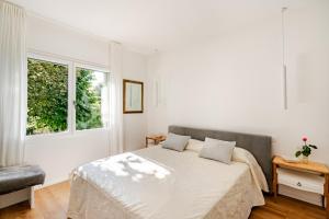 a white bedroom with a bed and a window at Villetta Risorgimento - 25 minutes from Venice in Mira