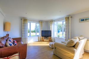 ein Wohnzimmer mit Sofa und Fernseher in der Unterkunft Lower Marsh Cottage in Brightlingsea