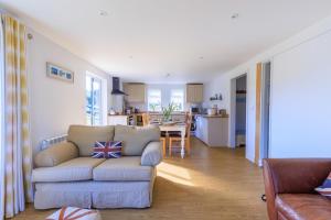 a living room with a couch and a kitchen at Lower Marsh Cottage in Brightlingsea