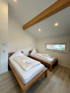 two beds in a room with a window at AlpenNest Mountain Oasis in Inzell in Inzell +14 photos