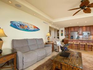 sala de estar con sofá y tabla de surf en la pared en Polo Beach Club 801, en Wailea 15 fotos más