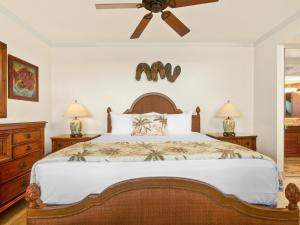 Un dormitorio con una cama con ventilador de techo. en Polo Beach Club 801, en Wailea