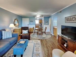 a living room with a couch and a tv and a table at Lighthouse Point by Tybee Vacation Rentals in Tybee Island
