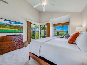 Un dormitorio con una cama grande y un televisor de pantalla plana. en Wailea Elua Village 910, en Wailea