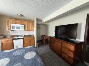 a small kitchen with a stove and a tv at Snowshoe Motel in Frisco