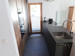 una cocina con fregadero y frigorífico en Chalet Betty, en Crans-Montana 30 fotos más