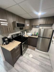 una cucina con mobili in legno e un frigorifero in acciaio inossidabile di Winnipeg Bright Home a Winnipeg