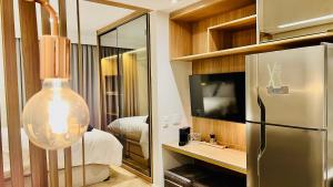 een kamer met een koelkast en een slaapkamer met een bed bij Flat Luxo Jardins com Piscina, Vaga e serviços in Sao Paulo