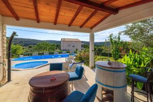 a patio with a table and chairs and a pool at Apartments Ankica in Kampor