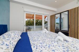 a bedroom with a bed with a blue and white comforter at Apartments Ankica in Kampor +52 photos