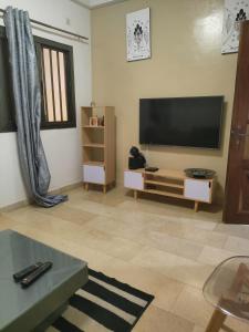 a living room with a flat screen tv on the wall at Even'place in Dakar