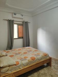 a bedroom with a bed in a room with a window at Even'place in Dakar