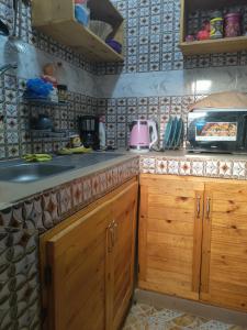 a kitchen with wooden cabinets and a counter top at Even'place in Dakar
