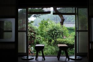 two stools in front of a window with a view at Akitsu Ryokan in Maibara