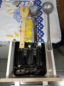 a utensil holder with a bunch of utensils at Sobrado de Container Azul in Dourados