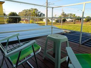 a pair of chairs and a table on a deck at Sobrado de Container Azul in Dourados