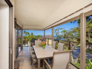 Un comedor con mesa y sillas en un balcón. en Wailea Elua Village 2102, en Wailea