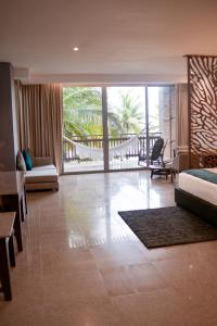 ein Hotelzimmer mit einem Bett und einem Wohnzimmer in der Unterkunft Castillete Hotel & Beach Club in Tierra Bomba + 81 Fotos