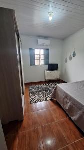 a bedroom with a bed and a desk with a laptop at casa kitnet in Maracaju