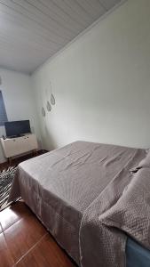 a bedroom with a bed and a laptop on a table at casa kitnet in Maracaju +1 photo