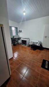an empty room with a kitchen and a wooden floor at casa kitnet in Maracaju
