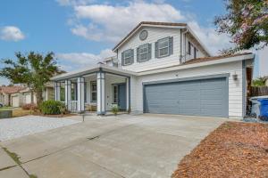 a white house with a garage at 7 Mi to Lake Yosemite Family Home with Fenced Yard in Merced