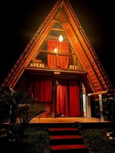 a small house with red curtains and a window at Hosteria Munay in Pedro Vicente Maldonado