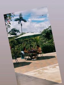 two people sitting at a table under an umbrella at Hosteria Munay in Pedro Vicente Maldonado