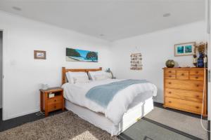 1 dormitorio blanco con 1 cama y vestidor en Coastal Serenity - Tapuaetahi Beach Escape, en Purerua