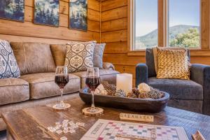 a living room with a couch and two glasses of wine at Mountain View Splash - Indoor Pool Hot Tub Game Room Stunning Smoky Mountain Views in Wear Valley