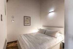 1 dormitorio blanco con 1 cama y una foto en la pared en Montevecchio6 Navona Residence, en Roma