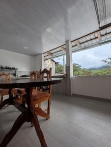 ミンドにあるTraveler's Houseのテーブルと椅子と窓のあるダイニングルーム