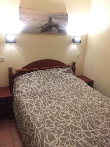 a bed in a room with two lights on the wall at Appartement T3 à Uhart-Cize in Uhart-Cize