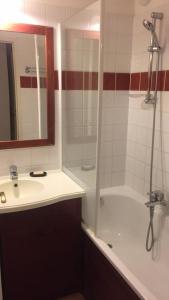 a bathroom with a sink and a shower and a tub at Appartement T3 à Uhart-Cize in Uhart-Cize