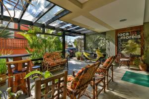 a patio with a table and chairs and plants at Hostel Toca da Moréia Bombinhas in Bombinhas