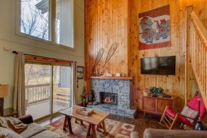 a living room with a fireplace and a tv at Slopeside Easy Street in Sugar Mountain