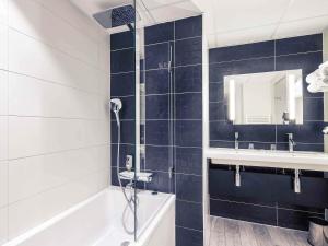 a bathroom with a shower and a tub and a sink at Mercure Colmar Centre Unterlinden in Colmar
