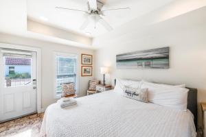 a bedroom with a white bed and a ceiling fan at Casa Mariposa SPV19 in Port Aransas