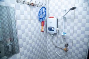 a shower with a blue and white tiled wall at Blaize Affaire Appartments in Kampala +65 photos