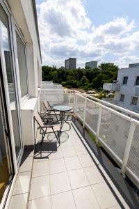 シュチェチンにあるRiver View Aparthotel Studio Auroraの建物の上にテーブルと椅子が置かれたバルコニー